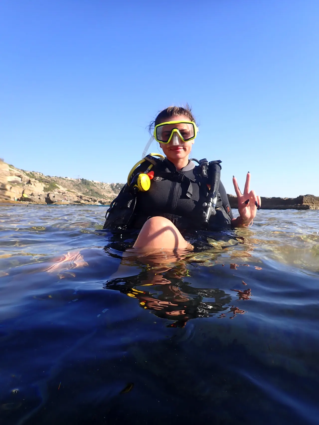 A guest at the surface of a Mallorcan bay after her first dive