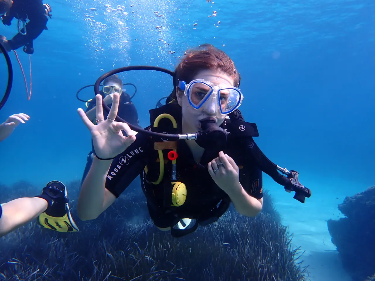 First-time diver underwater in Mallorca giving the OK hand signal