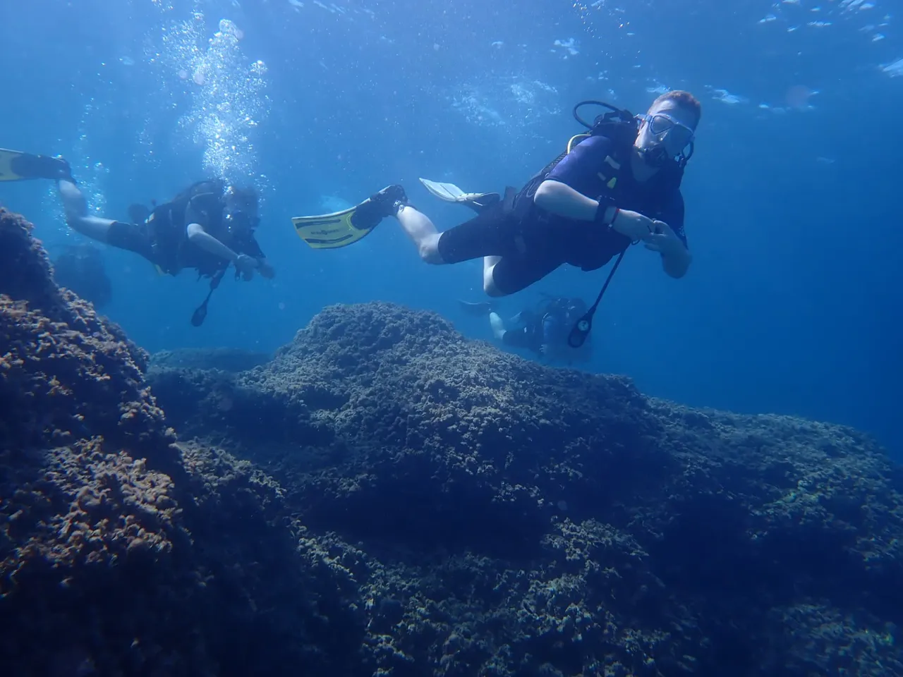 A small group of divers exploring the reef together