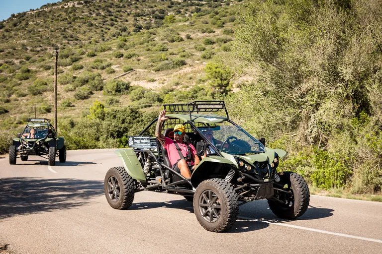 Road buggies on a winding paved road through green hills